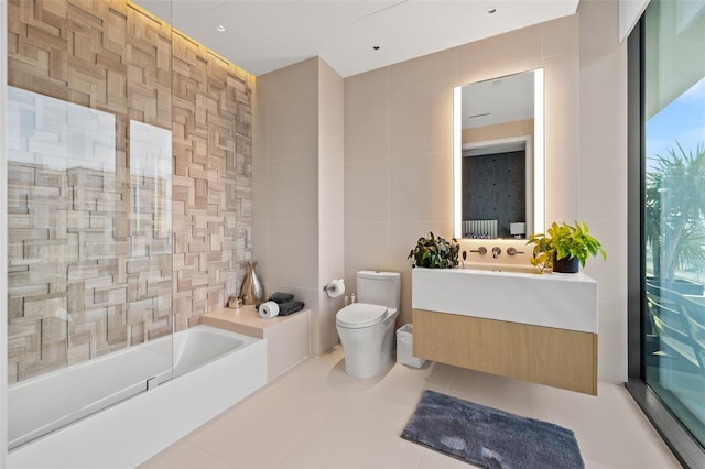 bathroom with toilet, tile flooring, tile walls, and large vanity