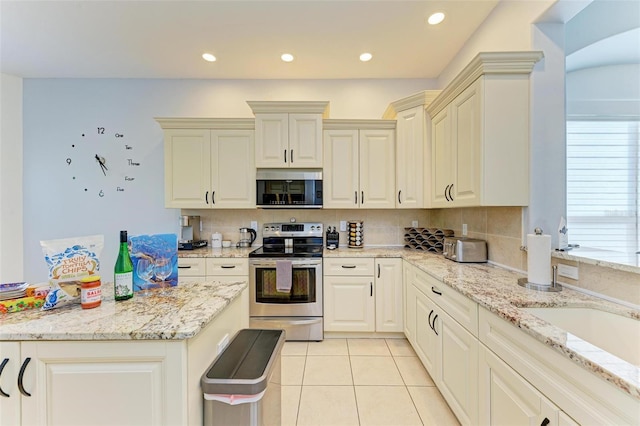 kitchen with a healthy amount of sunlight, stainless steel appliances, tasteful backsplash, and light stone counters