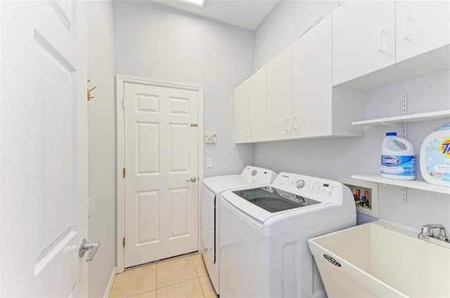 washroom with light tile flooring, independent washer and dryer, hookup for a washing machine, sink, and cabinets