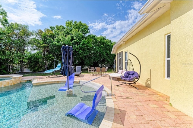 exterior space with a pool with hot tub and a patio area