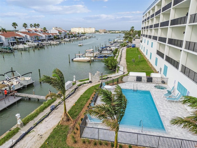 exterior space with fence, a patio area, a water view, and a boat dock