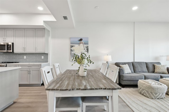 dining space with recessed lighting, visible vents, and light wood-style flooring