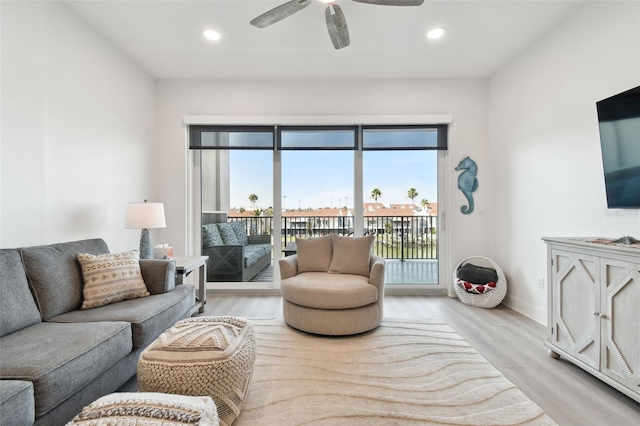 living room featuring light wood finished floors, recessed lighting, baseboards, and ceiling fan