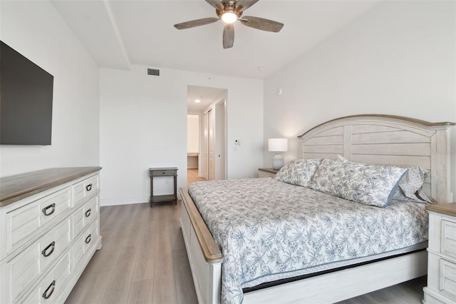 bedroom with visible vents, baseboards, a ceiling fan, and light wood finished floors