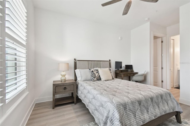 bedroom with ceiling fan, baseboards, and wood finished floors