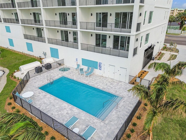 pool with a patio area and fence