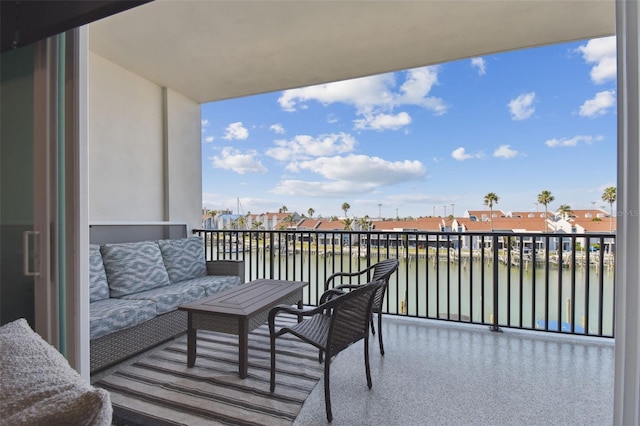 balcony with a residential view, outdoor lounge area, and a water view