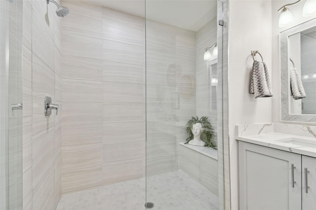 bathroom with vanity and a tile shower