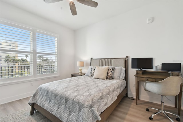 bedroom featuring a ceiling fan, wood finished floors, and baseboards