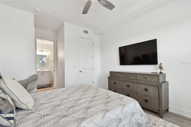 bedroom with a ceiling fan, visible vents, baseboards, ensuite bath, and light wood-style floors