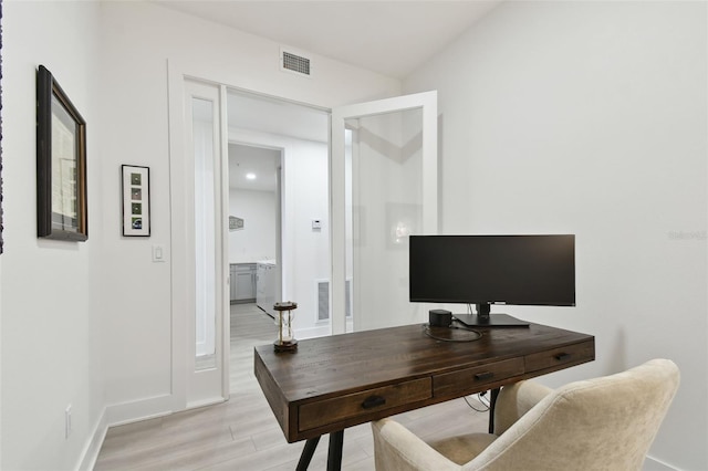 office area with visible vents, baseboards, and light wood finished floors