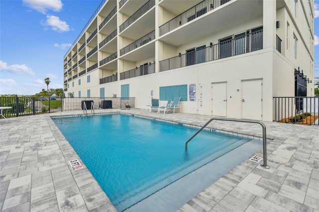 pool with a patio and fence