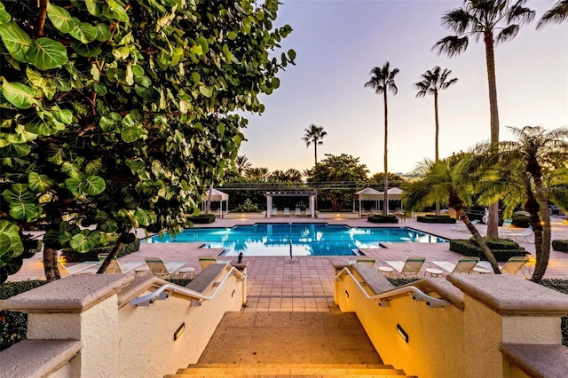 pool at dusk with a patio