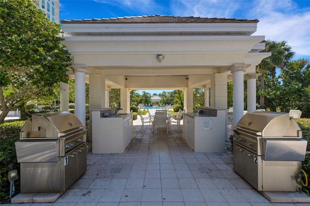 view of terrace with exterior kitchen, grilling area, and a gazebo