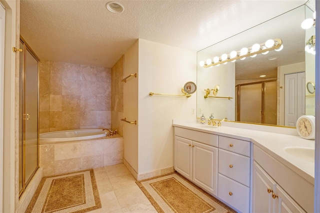 bathroom featuring tile flooring, dual sinks, oversized vanity, and a textured ceiling