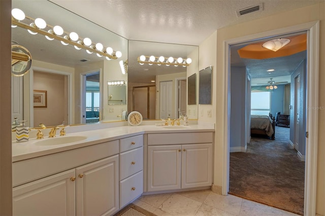 bathroom with tile flooring, a textured ceiling, ceiling fan, and double sink vanity