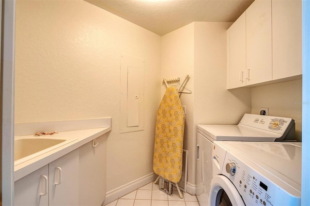 laundry room featuring cabinets, light tile floors, a textured ceiling, washer and clothes dryer, and electric dryer hookup