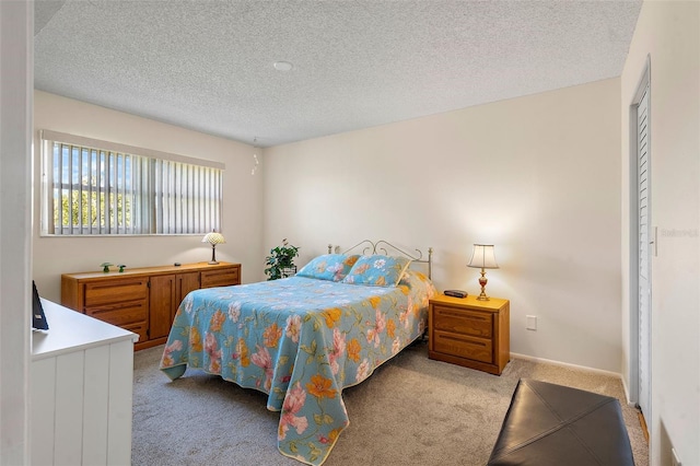 carpeted bedroom with a closet and a textured ceiling