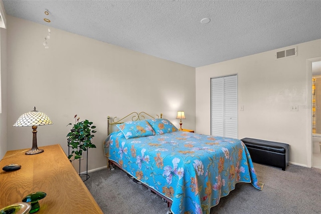 bedroom with a closet, a textured ceiling, and dark colored carpet