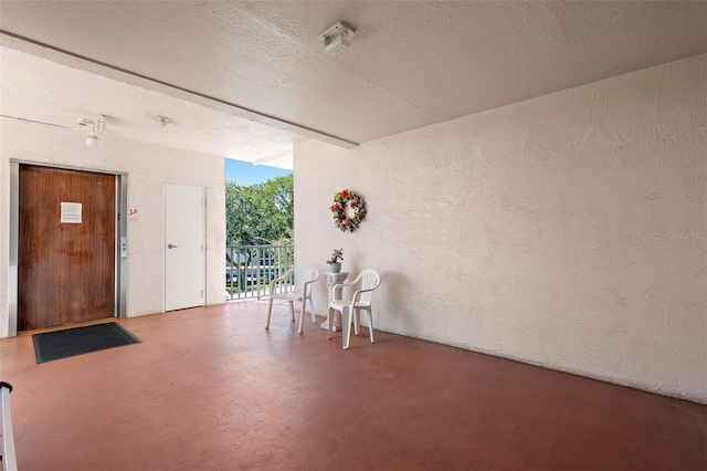 interior space featuring concrete floors and a textured ceiling