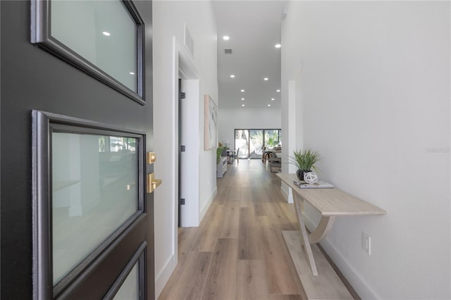 hallway with light hardwood / wood-style floors