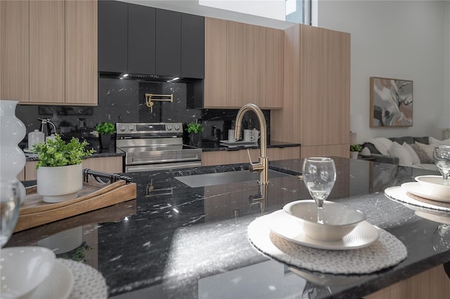 kitchen featuring tasteful backsplash, electric stove, dark stone countertops, and sink