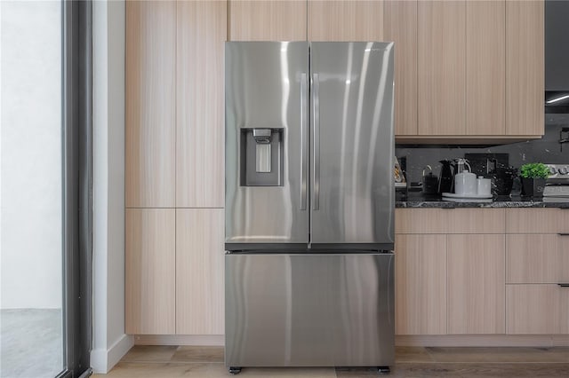 kitchen featuring stainless steel fridge with ice dispenser and light brown cabinetry