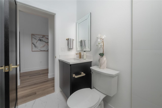 bathroom with toilet, vanity, and hardwood / wood-style flooring