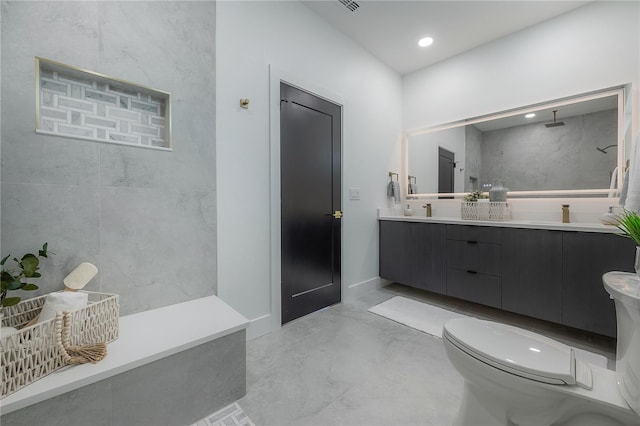 bathroom with tiled shower, vanity, concrete floors, and toilet