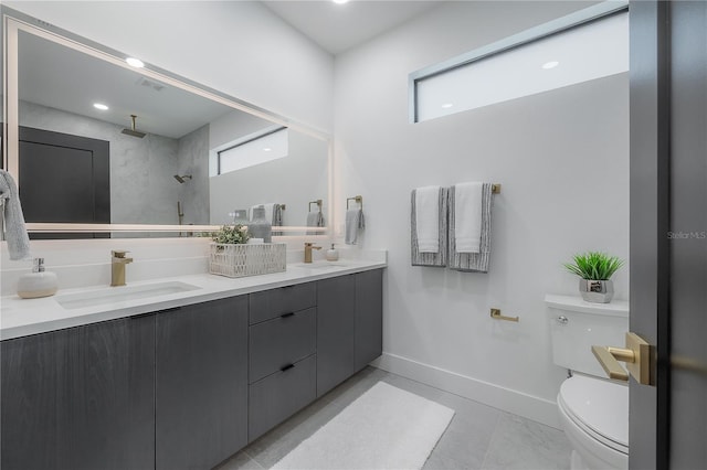 bathroom with vanity, toilet, and a tile shower