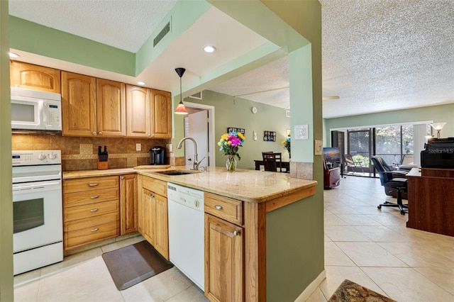 kitchen with sink, white appliances, backsplash, decorative light fixtures, and kitchen peninsula