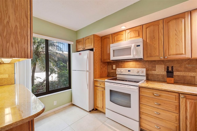 kitchen featuring white appliances, backsplash, light tile floors, and light stone countertops