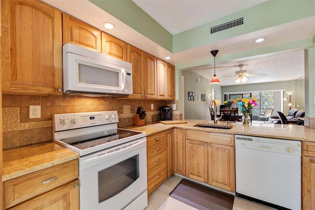 kitchen featuring white appliances, backsplash, sink, ceiling fan, and a textured ceiling