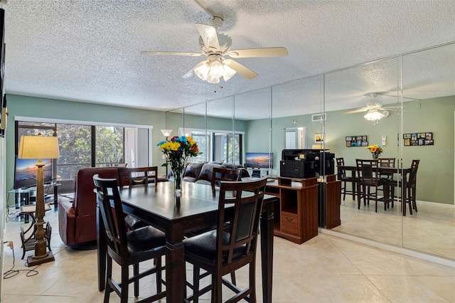 tiled dining area featuring ceiling fan and a textured ceiling