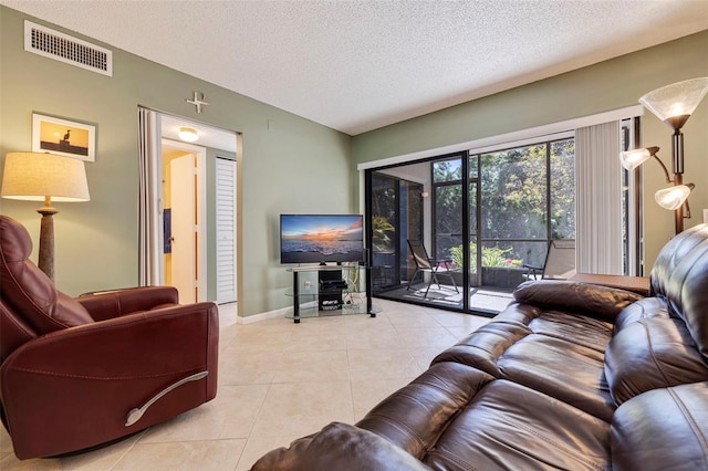 living room with a textured ceiling and light tile floors