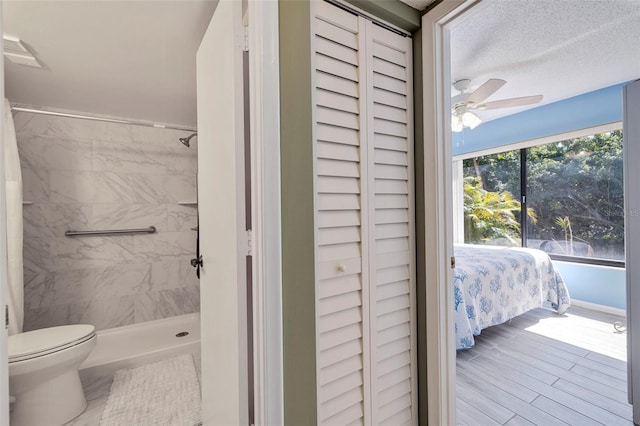 bathroom featuring a textured ceiling, ceiling fan, and toilet