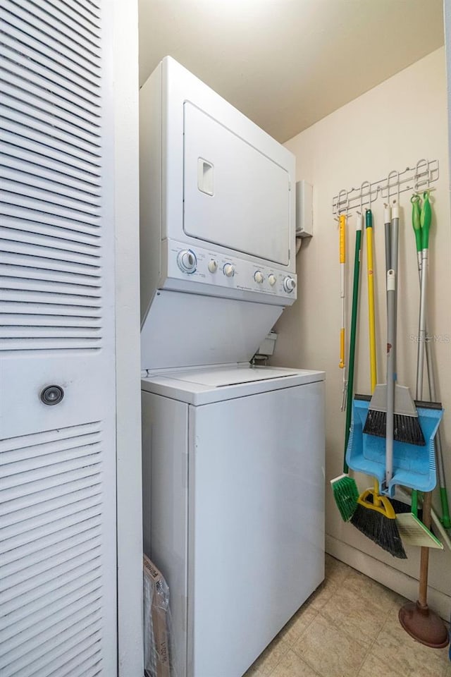 washroom with stacked washer and clothes dryer and light tile floors