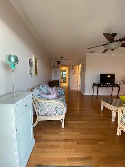 bedroom featuring crown molding, light hardwood / wood-style floors, and ceiling fan