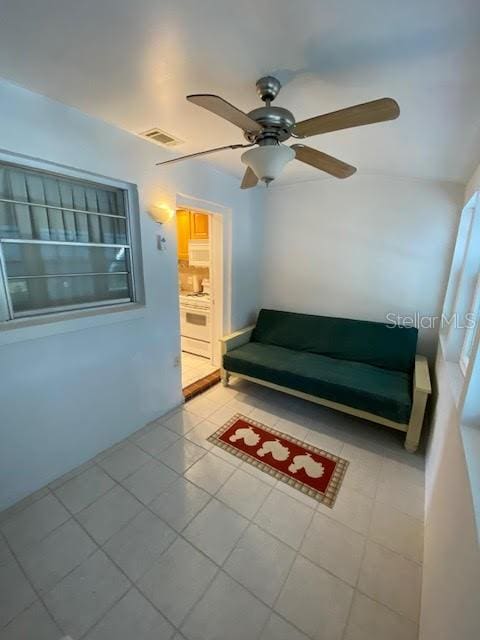 interior space with ceiling fan and light tile floors