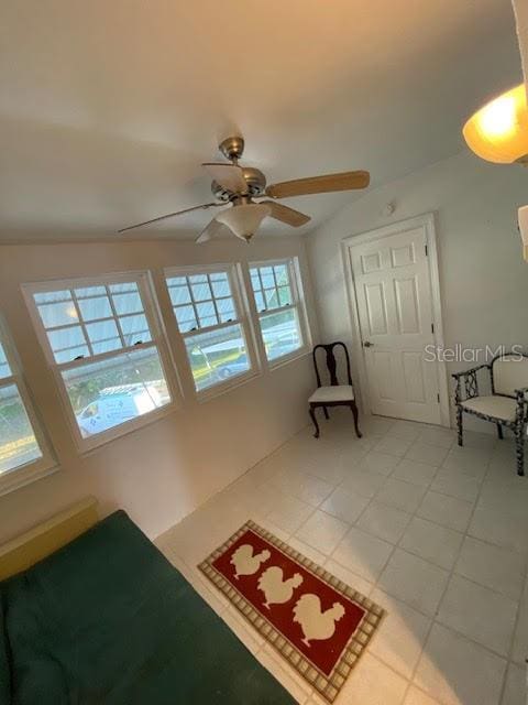 unfurnished living room featuring ceiling fan and light tile floors