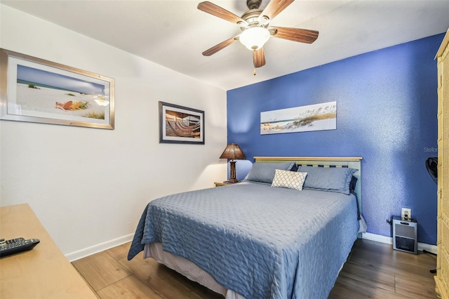 bedroom with ceiling fan and dark wood-type flooring