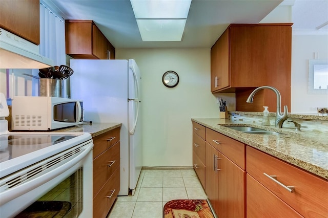 kitchen with ornamental molding, white appliances, light stone counters, sink, and light tile flooring