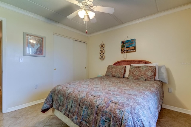 bedroom with tile floors, ceiling fan, a closet, and crown molding