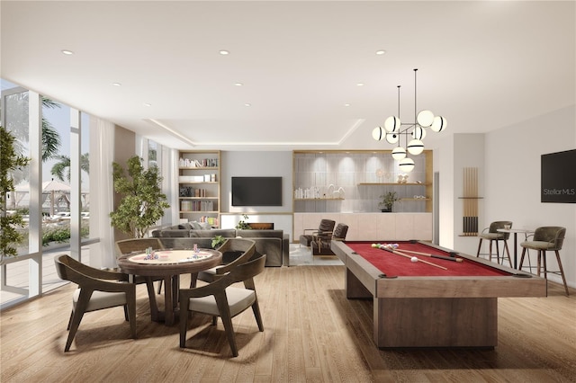 playroom featuring pool table, built in shelves, a chandelier, and light hardwood / wood-style floors