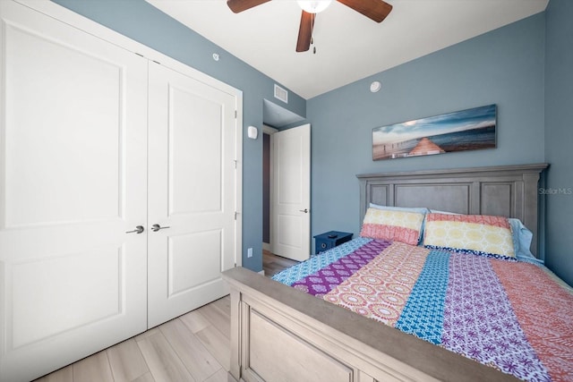 bedroom with light hardwood / wood-style flooring, a closet, and ceiling fan