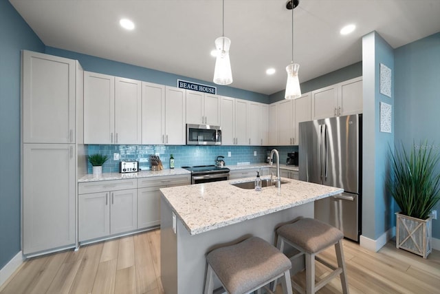 kitchen featuring light wood-type flooring, stainless steel appliances, backsplash, and white cabinets