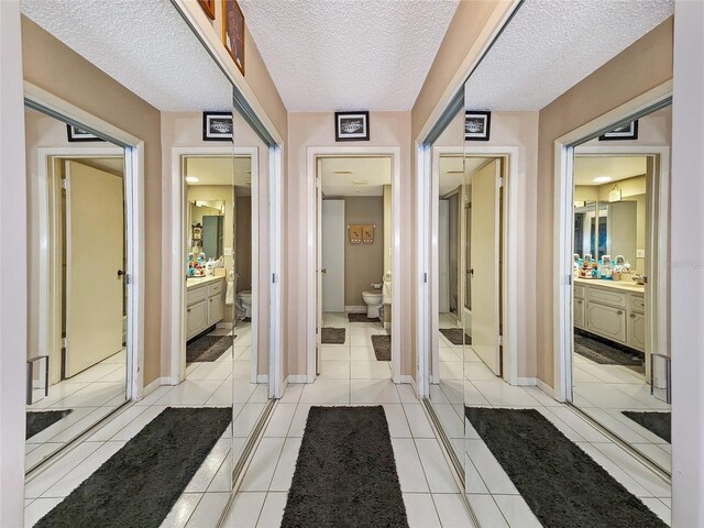 bathroom featuring toilet, vanity, tile patterned floors, and a textured ceiling