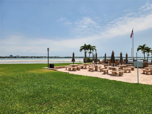 view of property's community with a water view and a lawn