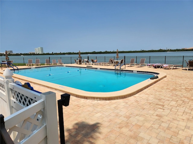 view of pool with a water view and a patio