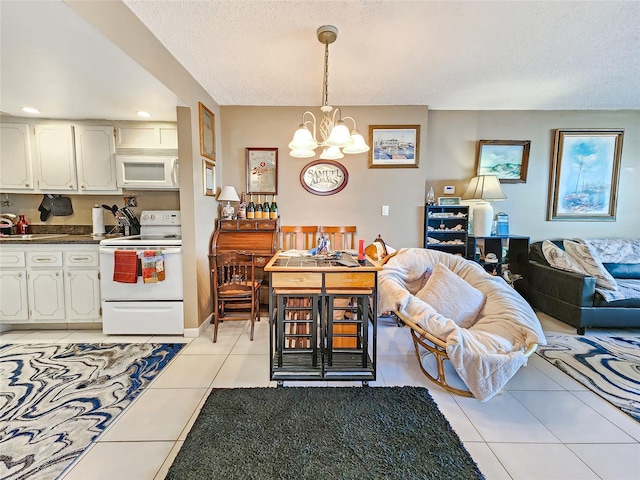 kitchen featuring light tile patterned floors, white cabinetry, a notable chandelier, white appliances, and pendant lighting